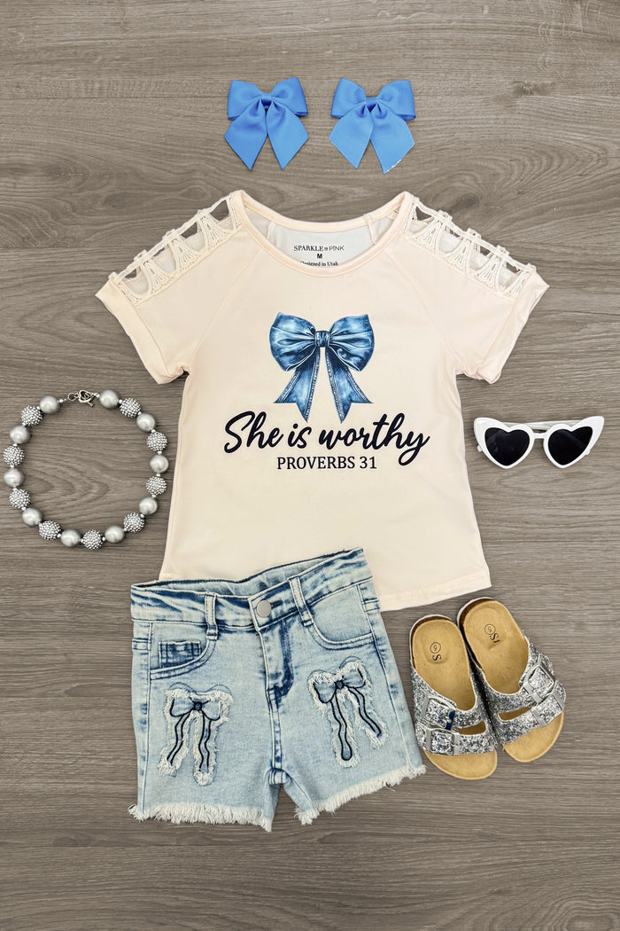 "She Is Worthy" Denim Bow Short Set - 6-12 Months - Cream short-sleeve top with "She is worthy" text and blue bow graphic, distressed denim shorts, blue denim hair bows, gray.