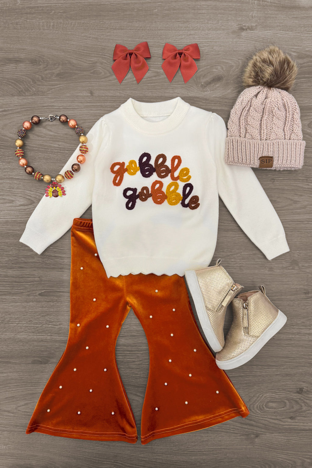 "Gobble Gobble" Pearl Flare Pant Set - 6-12 Months - Cream long-sleeve top with colorful “Gobble Gobble” lettering paired with rust flared pants and a pearl-studded finish.
