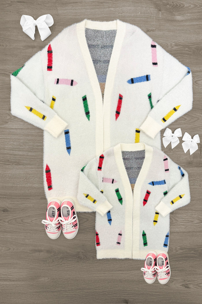 Mom & Me - Crayon Cardigan - CHILD-3T - Cream cardigan with colorful crayon patterns, V-neck, ribbed cuffs and hem, styled with white hair bows and pink baby shoes.