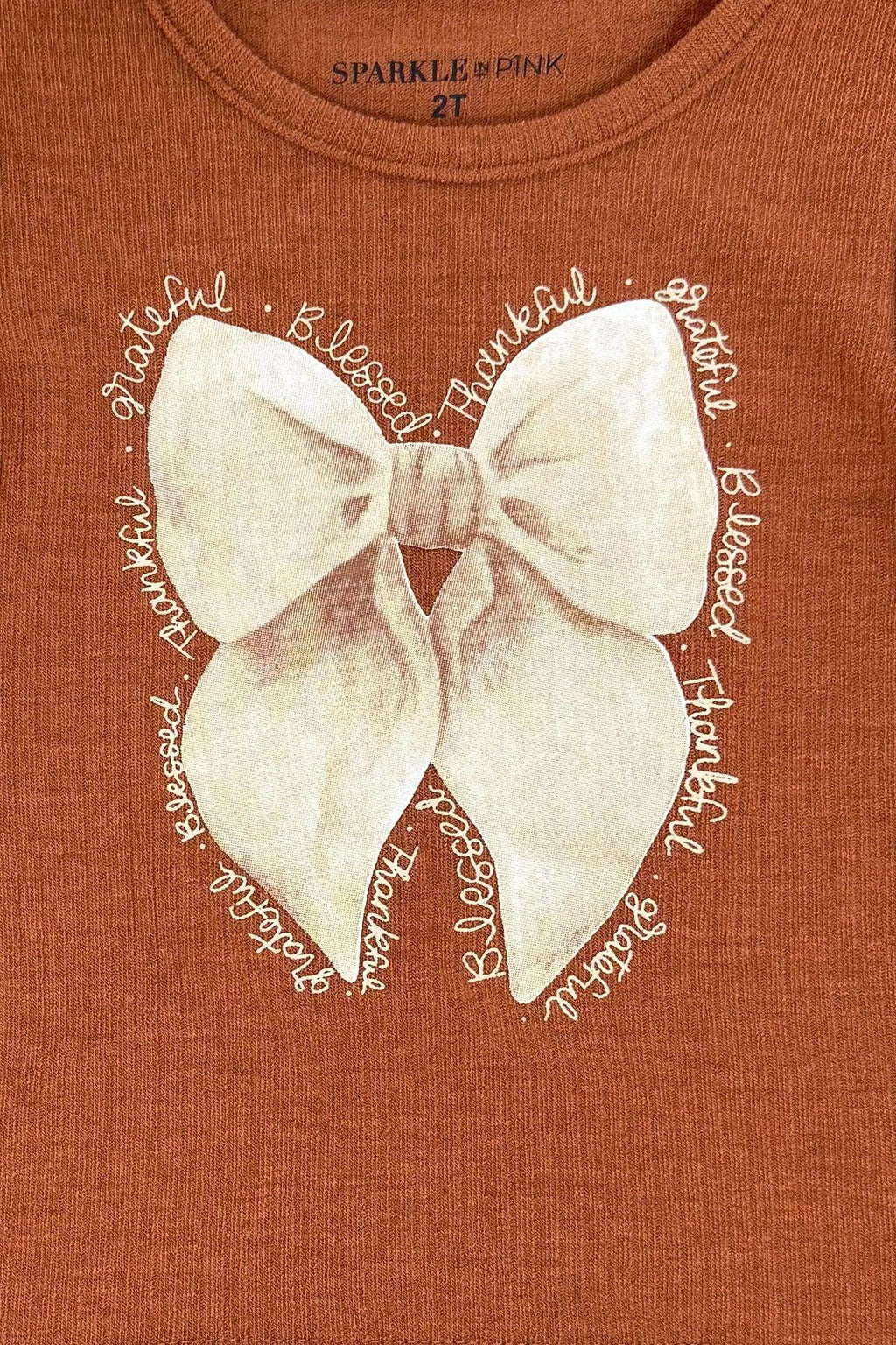"Grateful, Blessed, Thankful" Plaid Pant Set - 6-12 Months - Rust-brown T-shirt with a cream bow graphic and distressed white lettering reading “Grateful, Blessed, Thankful.”.