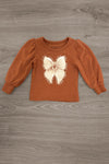 "Grateful, Blessed, Thankful" Plaid Pant Set - 6-12 Months - Rust long-sleeve toddler top with a large cream bow graphic and gathered sleeves.