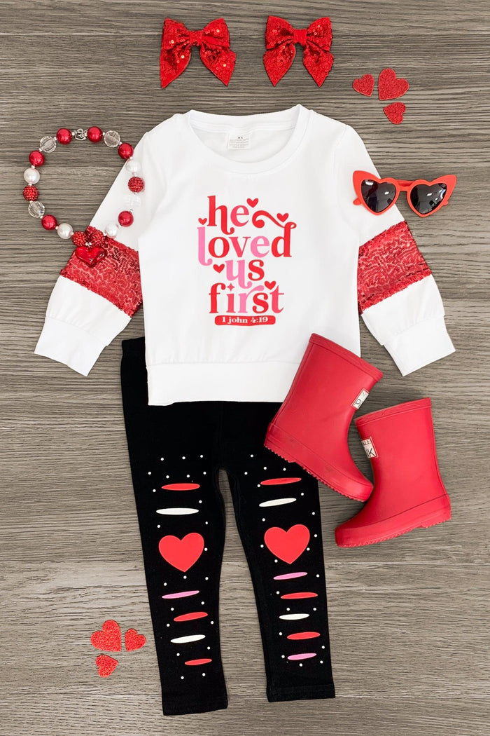 "He Loved Us First, John 4:19" Legging Set - 3XS-6-12 Months - White long-sleeve top with red "he loved us first" text and red lace sleeve accents with black leggings featuring ripped.