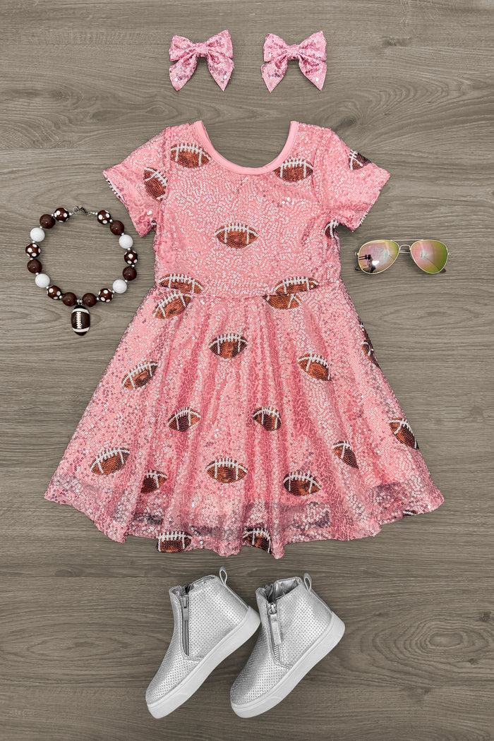 Pink Sequin Football Dress - 3XS-6-12 Months - Pink toddler dress with sequin footballs, short sleeves, and flared skirt, paired with matching pink bows, white sneakers,.