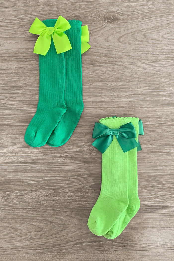 Green Knee High Silk Bow Socks - Light Green / Small-3T - Pair of green knee-high silk socks with large bows, one dark green and one light green on wood surface.