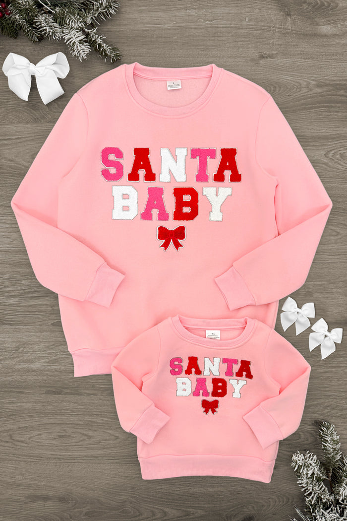 Mom & Me - "Santa Baby" Pink Sweatshirt - CHILD-3XS-6-12 Months - Pink sweatshirt set with "Santa Baby" text in red, white, and pink letters, featuring a small red bow graphic beneath.