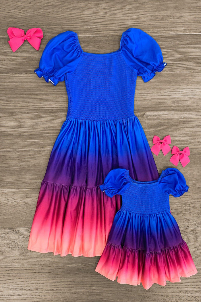 Mom & Me - Blue Sunset Ruffle Dress - CHILD-3XS-6-12 Months - Matching blue to pink ombre ruffle dresses for mom and child with puff sleeves and smocked bodices, paired with pink bows.