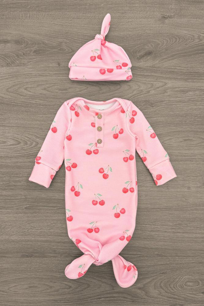 Pink Cherry Waffle Knit Onesie Set & Blanket - Baby / Newborn - Pink waffle knit baby onesie with cherry print and matching knotted hat on wood background.
