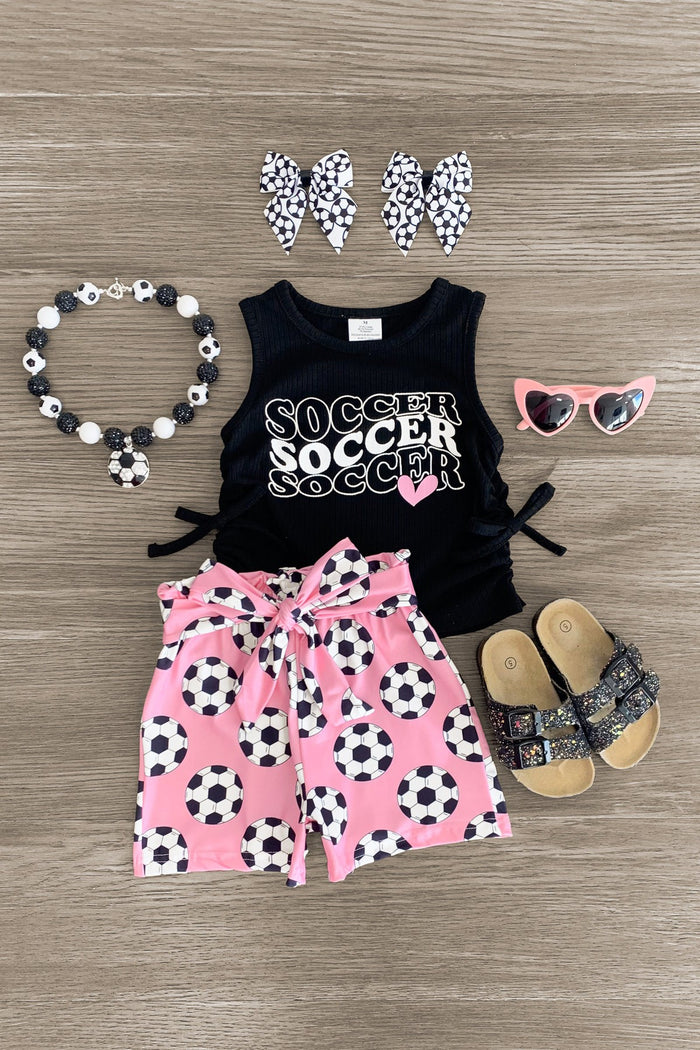 "Soccer" Black & Pink Short Set - 3XS-6-12 Months - Black sleeveless top with white "Soccer" print and pink heart, paired with pink shorts covered in black-and-white soccer.
