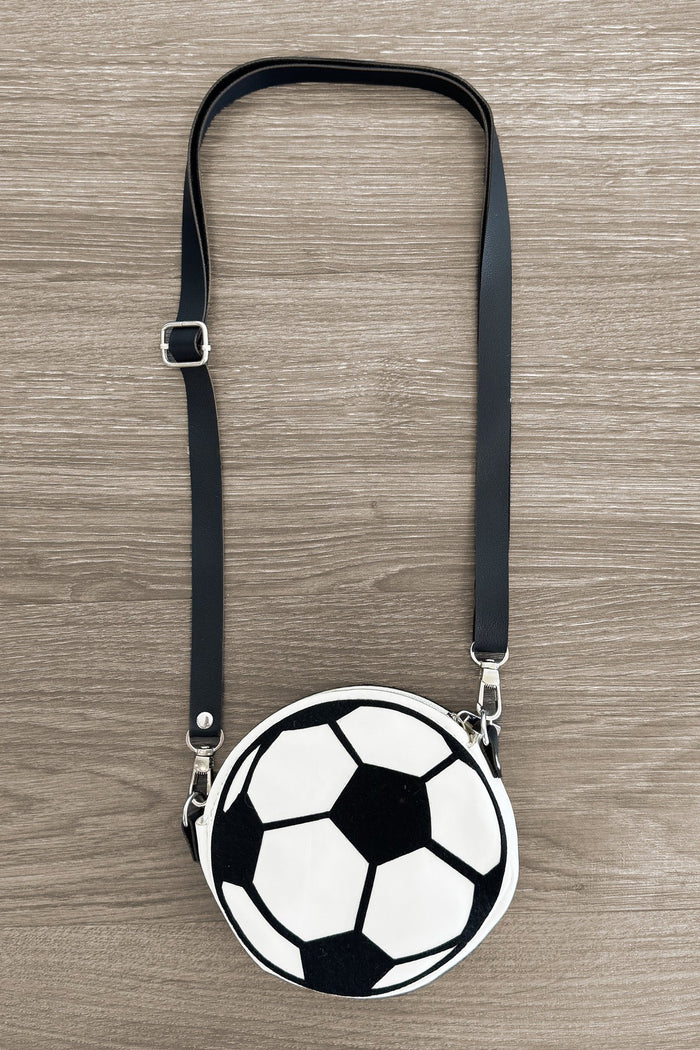 Soccer Ball Purse - Default Title - Round purse shaped like a black and white soccer ball with adjustable black strap on wood background.