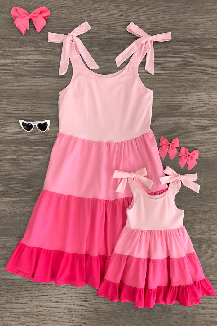 Mom & Me - Pink Tiered Tank Dress - CHILD-3XS-6-12 Months - Pink tiered tank dress with bow-tie straps in varying shades of pink, shown in adult and child sizes with matching pink hair .
