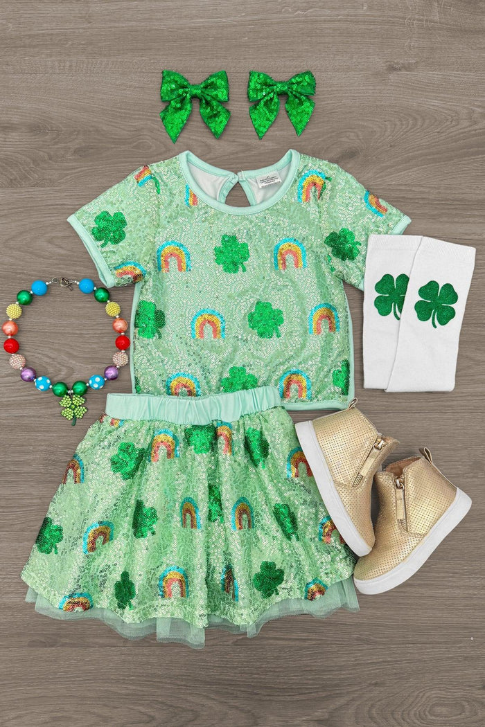 Rainbow & Shamrock Sequin Skirt Set - 6-12 Months - Green sequin skirt and short-sleeve top with rainbows and shamrocks, paired with shamrock bow clips, green clover leg.