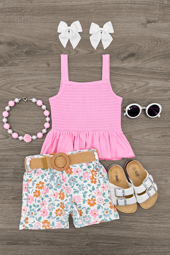 Pink Floral Short Set - 6-12 Months - Pink smocked tank top with floral shorts, tan sandals, white bow clips, beaded necklace, and round sunglasses on wood.