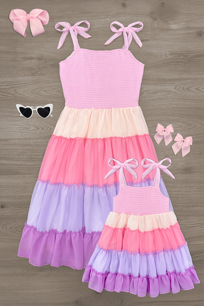 Mom & Me - Tiered Purple Dress - CHILD-6-12 Months - Matching tiered pink and purple sleeveless dresses with bows on straps, styled with heart-shaped sunglasses and pink hair.
