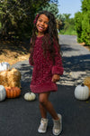 Sparkle Plush Sequin Long Sleeve Dress - Green / 6-12 Months - Burgundy plush sequin dress with long sleeves and fitted silhouette on a smiling girl outdoors.