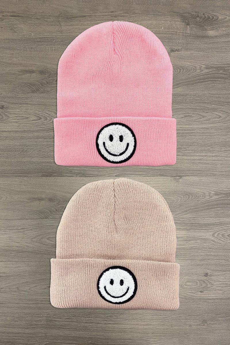 Smiley Face Beanies - Pink - Pink and tan knit beanies each with a black and white smiley face patch on the cuff.