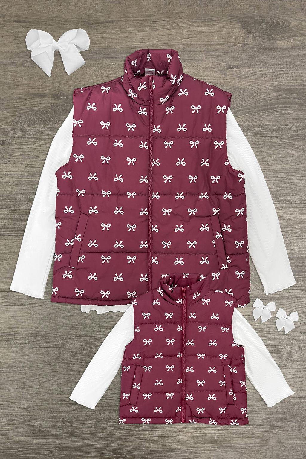 Mom & Me - Bow Vest Set - CHILD-6-12 Months - Matching burgundy quilted vests with white bow pattern, paired with white long-sleeve tops and large white hair bows.