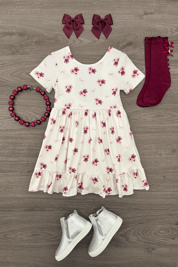 Pink Flowers & Bows Dress - 6-12 Months - White short-sleeve dress with pink and purple floral print, gathered waist, paired with burgundy bows, matching socks,.