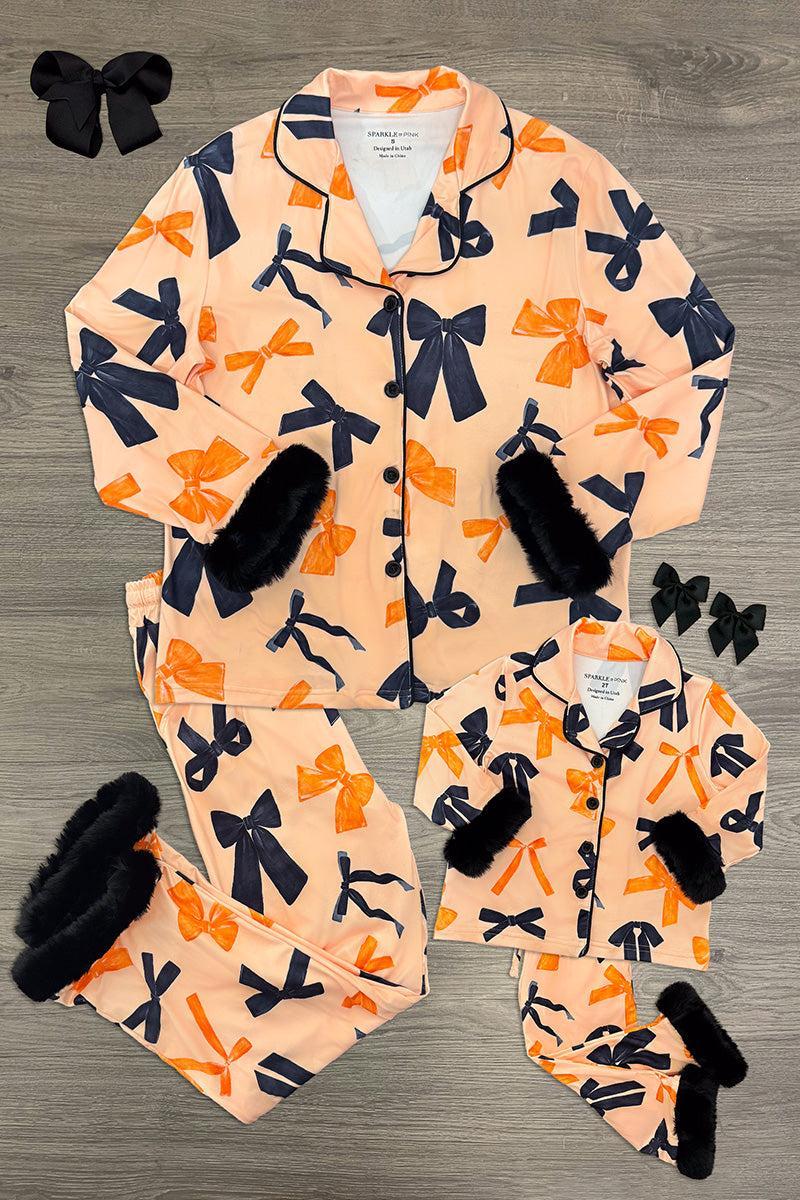 Mom & Me - Fuzzy Orange & Black Bow Pajamas - CHILD-6-12 Months - Matching orange fuzzy pajamas with large black bows, black cuffs, and button-up tops for mom and child, styled flat with.