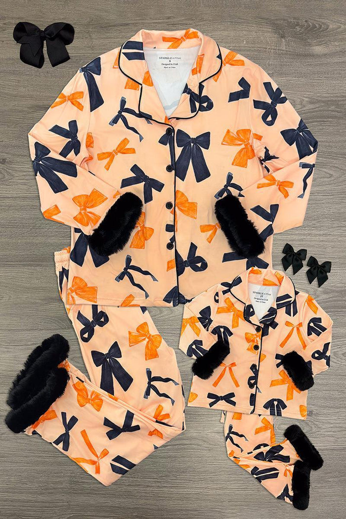 Mom & Me - Fuzzy Orange & Black Bow Pajamas - CHILD-6-12 Months - Matching orange fuzzy pajamas with large black bows, black cuffs, and button-up tops for mom and child, styled flat with.