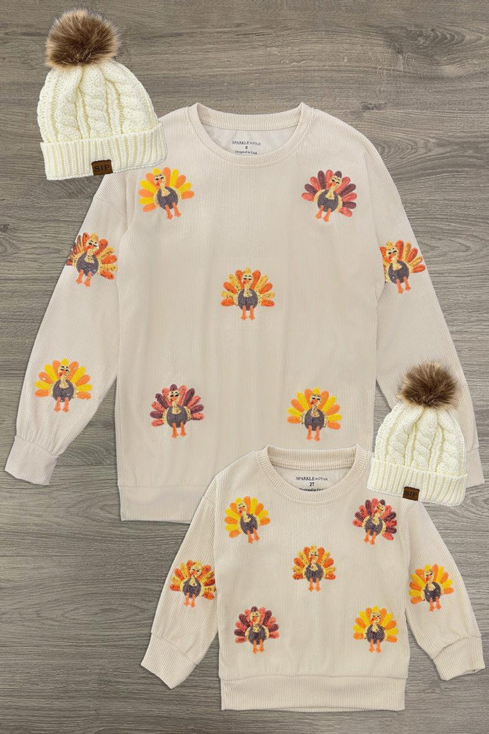 Mom & Me - Corduroy Sequin Turkey Top - CHILD-6-12 Months - Cream long-sleeve tops with colorful sequin turkey motifs, paired with cream knit pom-pom beanies.