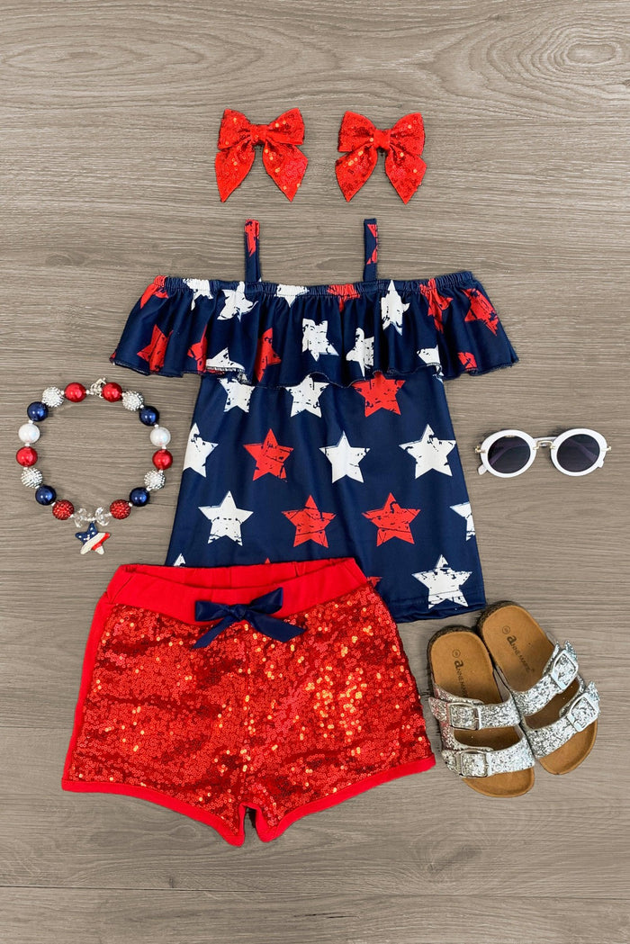 Navy & Red Stars Sequin Short Set - 6-12 Months - Navy off-shoulder top with red and white stars, red sequin shorts with navy bow, red star hair bows, multicolor beaded.