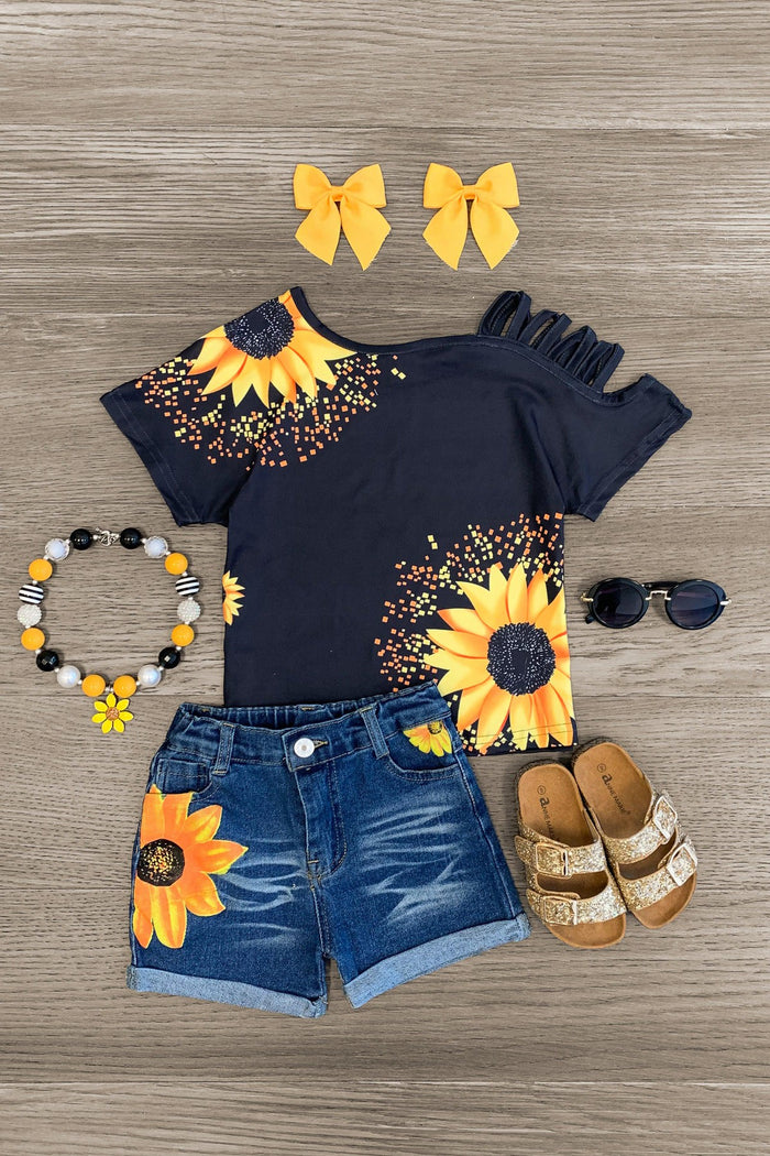 Sunflower Open Shoulder Denim Short Set - 3XS-6-12 Months - Black open-shoulder denim short set with sunflower print, paired with yellow bows, beaded bracelet, sunglasses, and sandals.