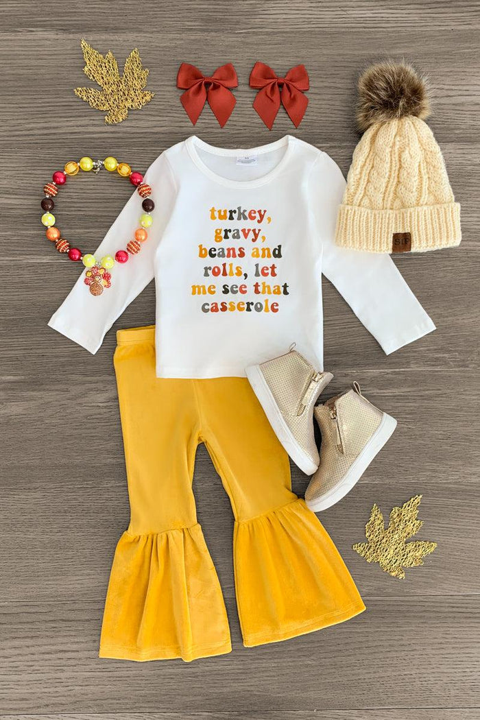 "...Let Me See That Casserole" Bell Bottom Set - 3XS-6-12 Months - White long-sleeve bodysuit with orange text, mustard yellow bell-bottom pants, beige knit hat with pom-pom, red bows, and.