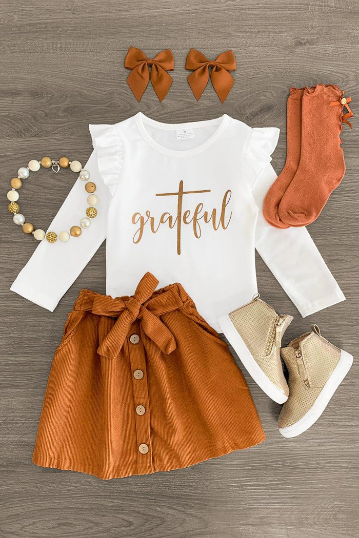 "Grateful" White Corduroy Skirt Set - 3XS-6-12 Months - White long-sleeve shirt with "grateful" text, rust corduroy button skirt, matching socks, tan shoes, bows, and beaded.