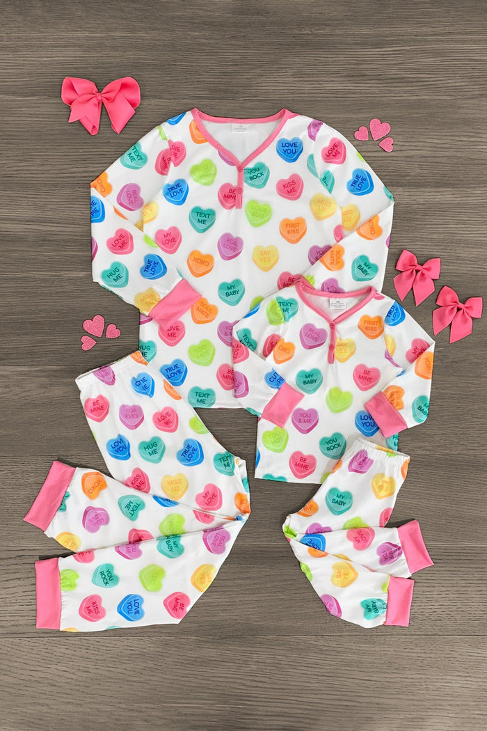 Mom & Me - White Candy Heart Pajamas - BABY-Newborn - Matching white pajamas with colorful candy heart prints and pink cuffs, featuring long sleeves and pants, styled for mom and .