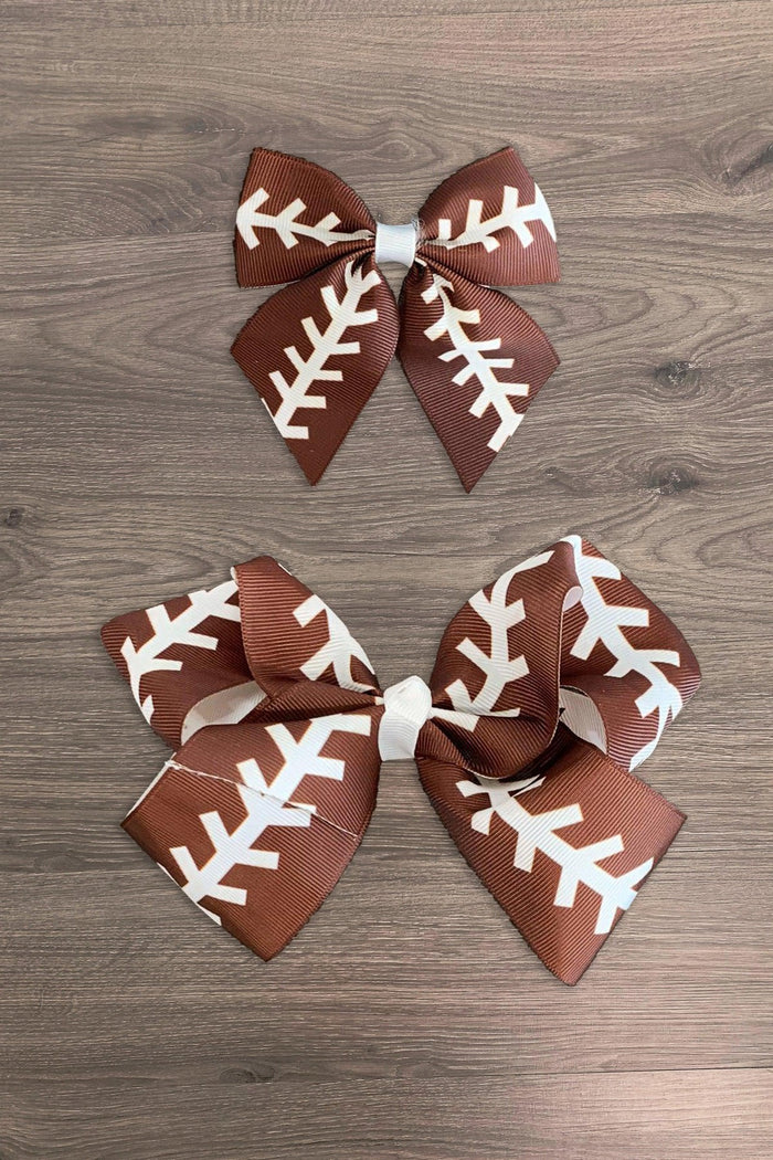 Football Bows - Small - Brown football-themed hair bows with white laces, available in small and large sizes, on wooden surface.