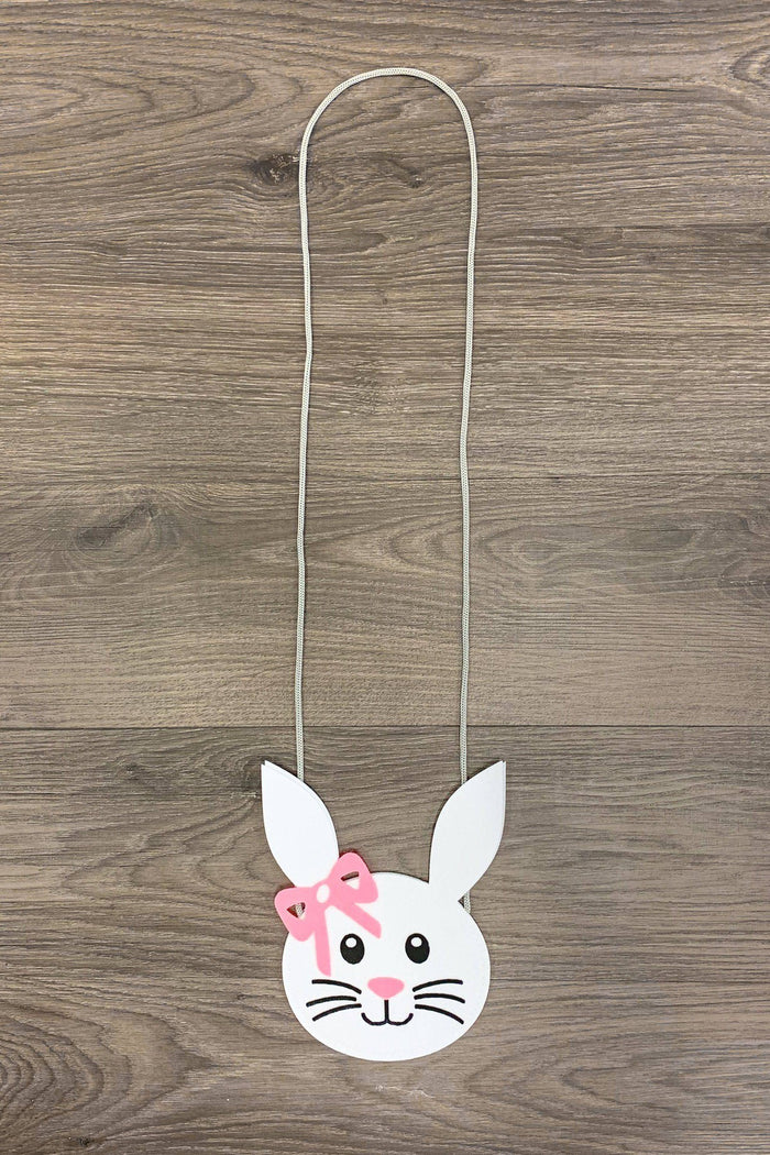 Brielle Bunny Purse - Default Title - White bunny-shaped purse with pink bow and long silver chain strap on wooden background.