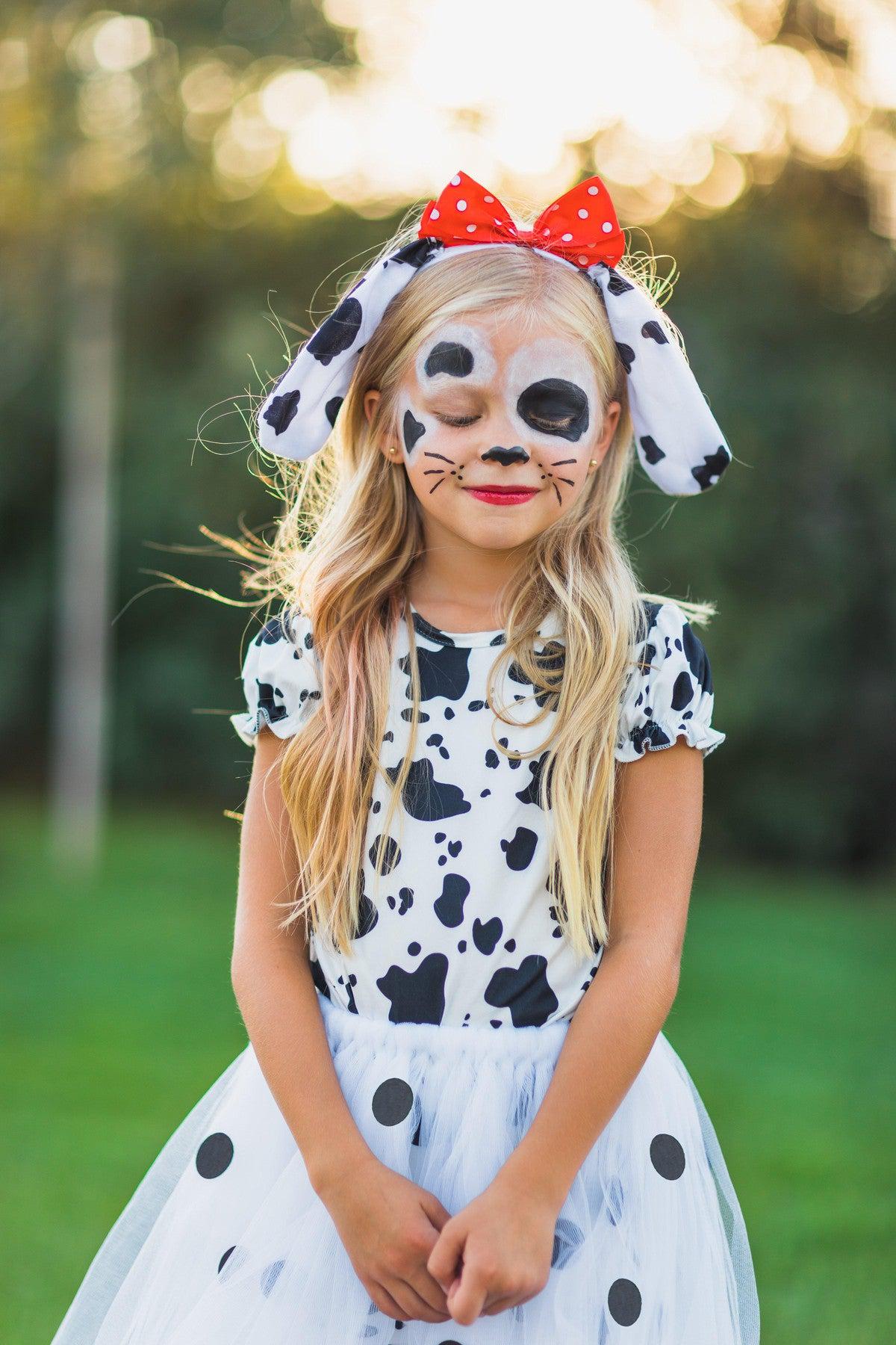 Dalmatian 5 Piece Costume Set - XXS-12-18 Months - Girl wearing white Dalmatian costume dress with black spots, floppy spotted ears, red bow headband, and face paint with.