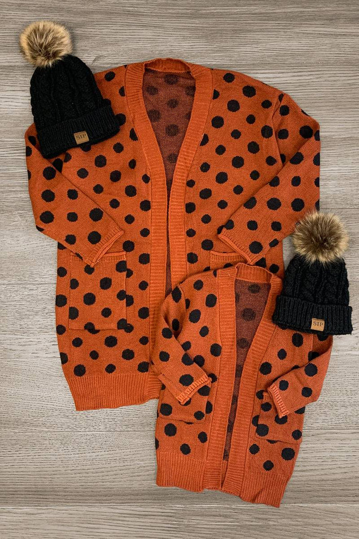 Mom & Me - Polka Dot Cardigan - CHILD-2XS-12-18 Months - Matching burnt orange cardigans with black polka dots, one adult and one child size, displayed flat with black knit hats.